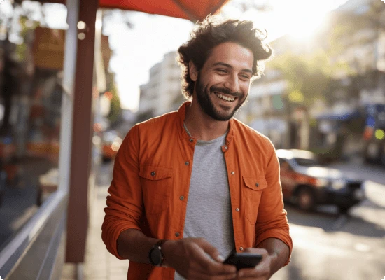 Homem sorridente com celular nas mãos
