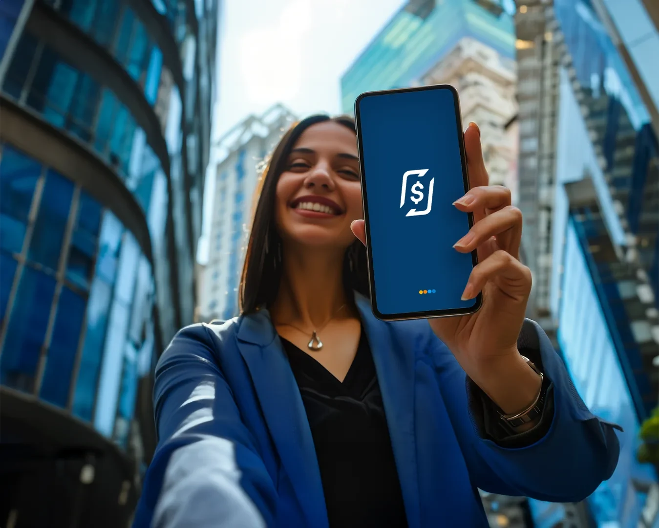 Mulher sorridente de blazer azul segurando um celular com o logo do RecargaPay, vista de baixo entre prédios de vidro