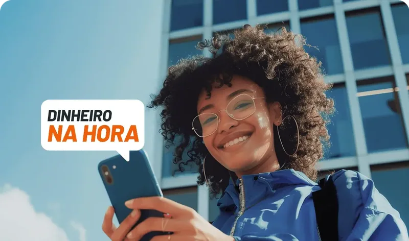 Mulher sorrindo segurando um celular com a mensagem Dinheiro na hora.