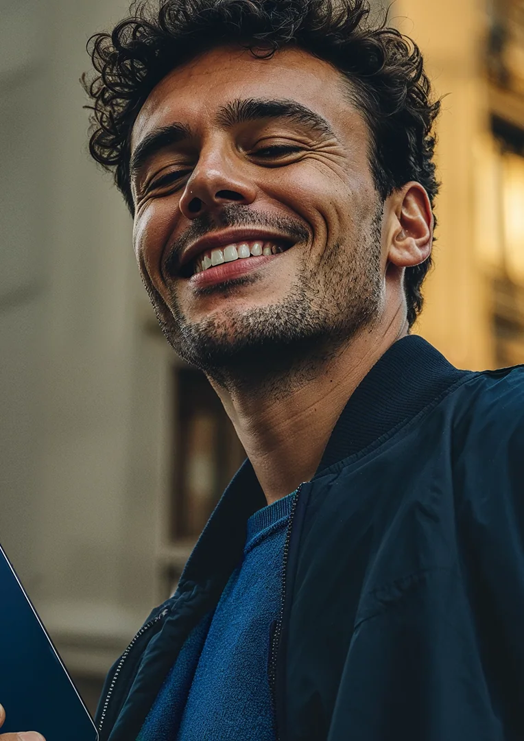 Homem sorrindo ao usar o celular.