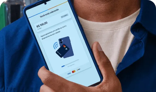 Mão segurando um celular com a tela de cobrança por aproximação do Tap to Pay RecargaPay